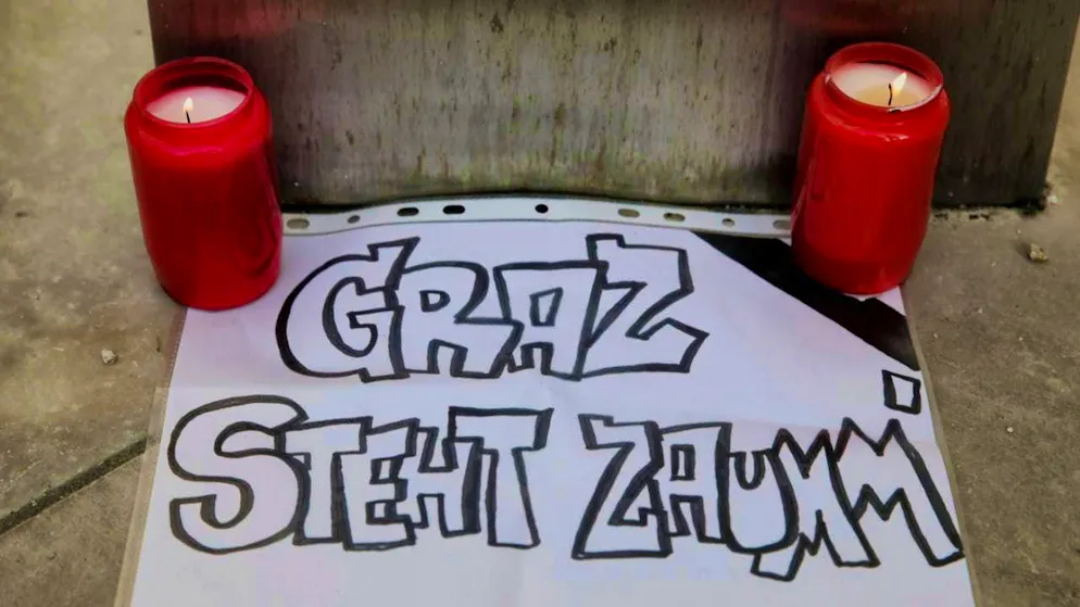 Candles stand next to a piece of paper with the inscription "Graz stands together". According to the authorities, a 21-year-old from the Graz area fired the fatal shots at a high school in Graz, Austria. Photo: Heinz-Peter Bader/AP/dpa