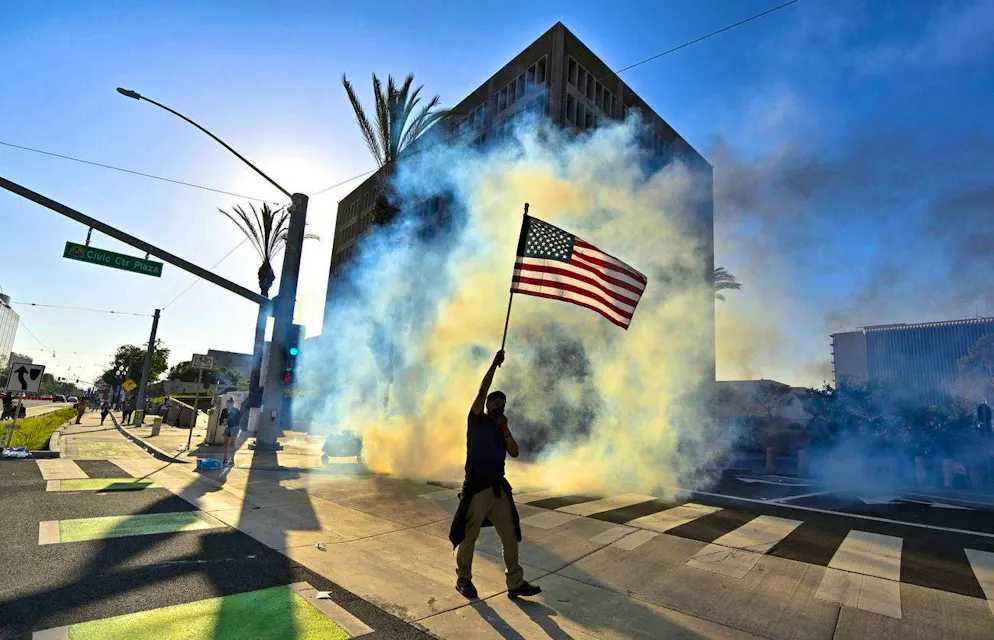 Protests L.A.. The tear gas does not stop this activist from waving the US flag.