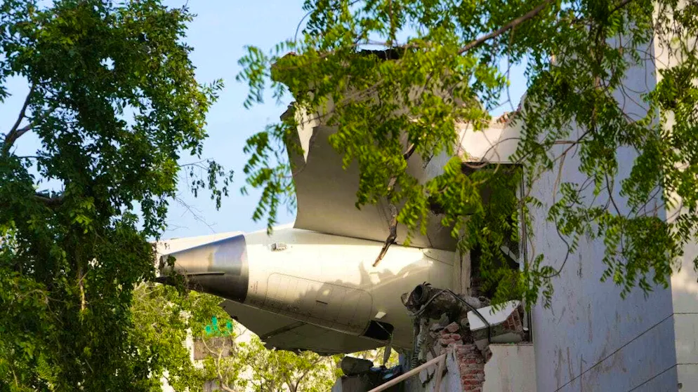 dpatopbilder - The debris of an airplane protrudes from a building after it crashed in the northwestern city of Ahmedabad in the Indian state of Gujarat. Photo: Ajit Solanki/AP/dpa