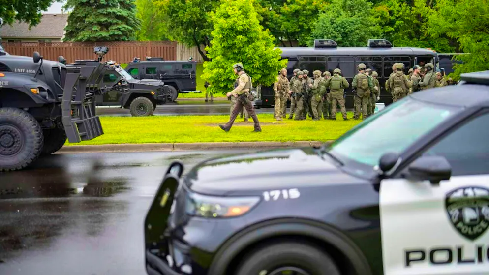 Law enforcement officials stand near the scene of the crime in Brooklyn Park, Minnesota. (June 14, 2025)