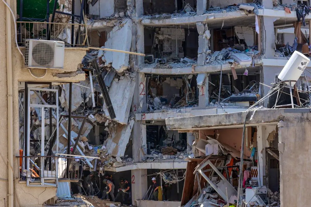 En bas d'immeubles aux façades totalement éventrées, certains sont en train de ranger, de passer le balai, au milieu du va-et-vient des engins de chantiers qui déblaient la chaussée.