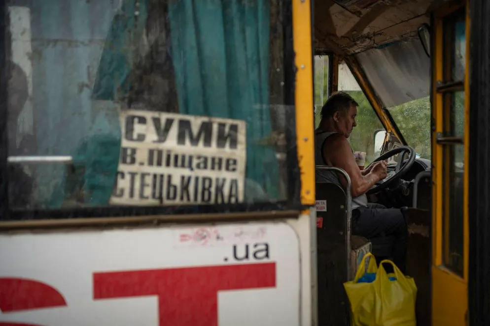 Sous une pluie battante, un chauffeur de bus attend les derniers passagers à Stetskivka, village fantôme à 17 km du front, tandis que l’armée russe progresse vers Soumy.