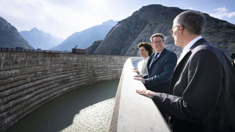 Barbara Egger-Jenzer présidente du conseil d'administration des KWO (gauche), le conseiller fédéral Albert Roesti (centre) et Daniel Fischlin CEO des KWO se tiennent sur le nouveau barrage de Spitallamm, haut de 113 mètres au lac du Grimsel vendredi.