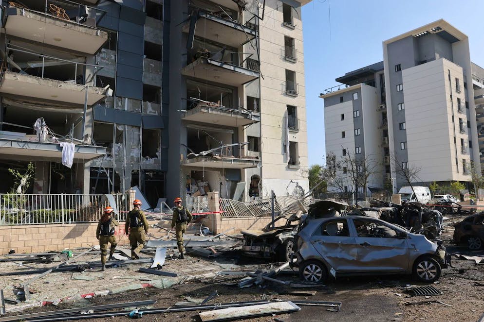 Guerra tra Iran e Israele. Un membro del team del Comando del Fronte Interno Israeliano cammina sul sito in cui i missili balistici iraniani hanno colpito edifici residenziali a Beer Sheva, nel sud di Israele.