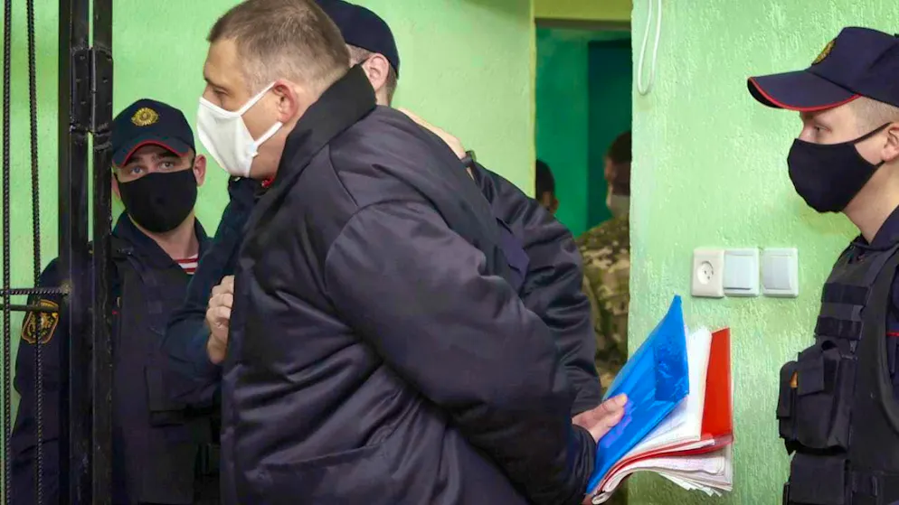 HANDOUT - Sergei Tikhanovsky (M), husband of Belarusian opposition leader Tikhanovskaya, is led in handcuffs towards a cage in the courtroom of the pre-trial detention center in Gomel. Photo: Sergei Kholodilin/BelTa/AP/dpa