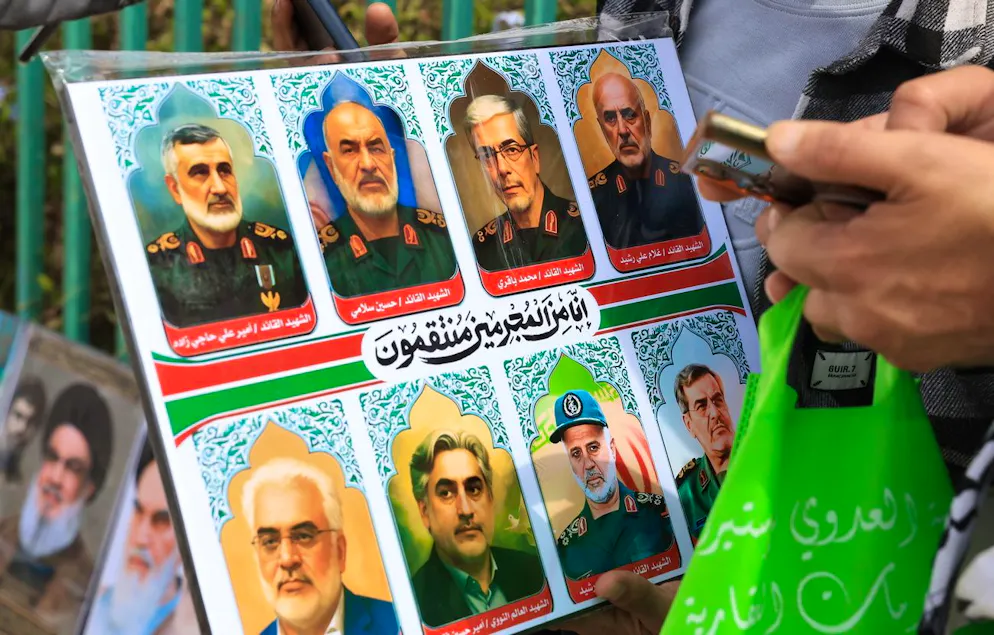 Un partisan des Houthis brandit les portraits de responsables militaires et de scientifiques nucléaires iraniens tués lors de frappes aériennes israéliennes, dans une rue de Sanaa, au Yémen, le 20 juin 2024. Israël et l'Iran s'affrontent depuis le 13 juin 2025, date à laquelle Israël a lancé des frappes à travers l'Iran dans le cadre de l'opération « Lion rugissant ».