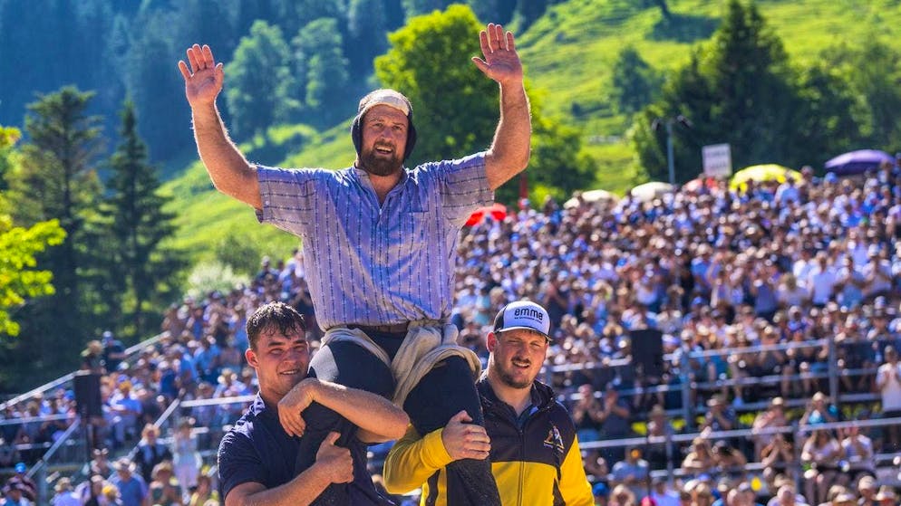 Matthias Aeschbacher wins the Bergschwinget Schwarzsee and is shouldered by final round opponent Michael Moser (left), among others.
