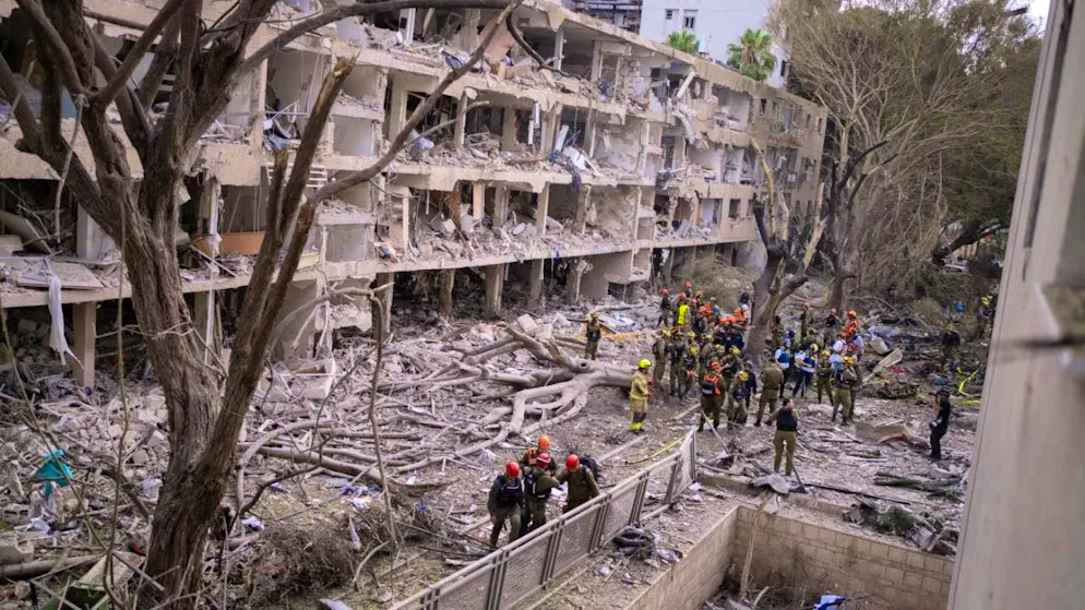 Rescue workers gather around a destroyed building after Iranian attacks on Israel. Photo: Ilia Yefimovich/dpa