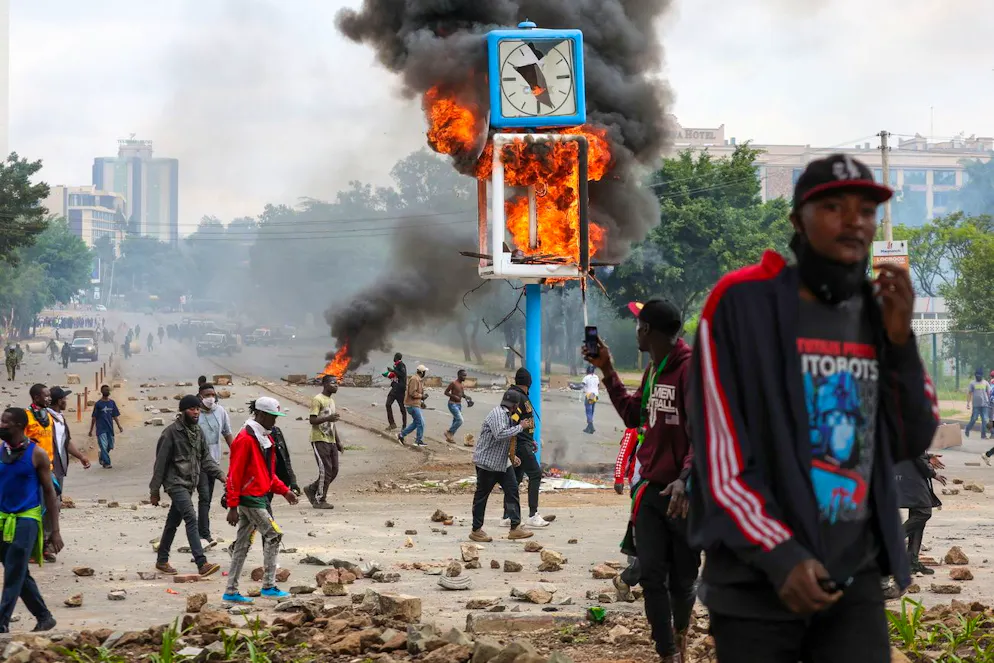 Un poteau d'horloge urbaine incendié par des manifestants brûle lors d'une manifestation dans le quartier central des affaires de Nairobi, au Kenya, le 25 juin 2025. Cette manifestation marque le premier anniversaire des manifestations de la génération Z, qui ont culminé avec l'assaut du parlement national.