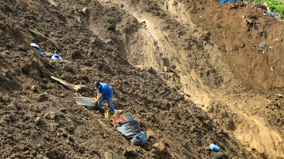 A man gathers his belongings after a deadly landslide was triggered by heavy rains in the Colombian municipality of Bello. Photo: Fredy Amariles/AP/dpa