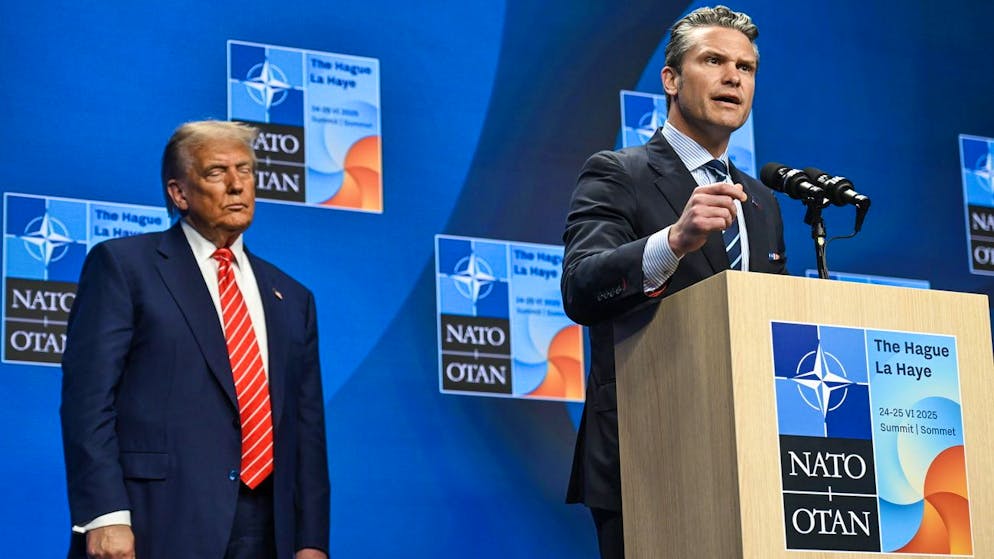 US-Verteidigungsminister Pete Hegseth am Mittwoch in Den Haag, hinter ihm sein Chef, US-Präsident Donald Trump.