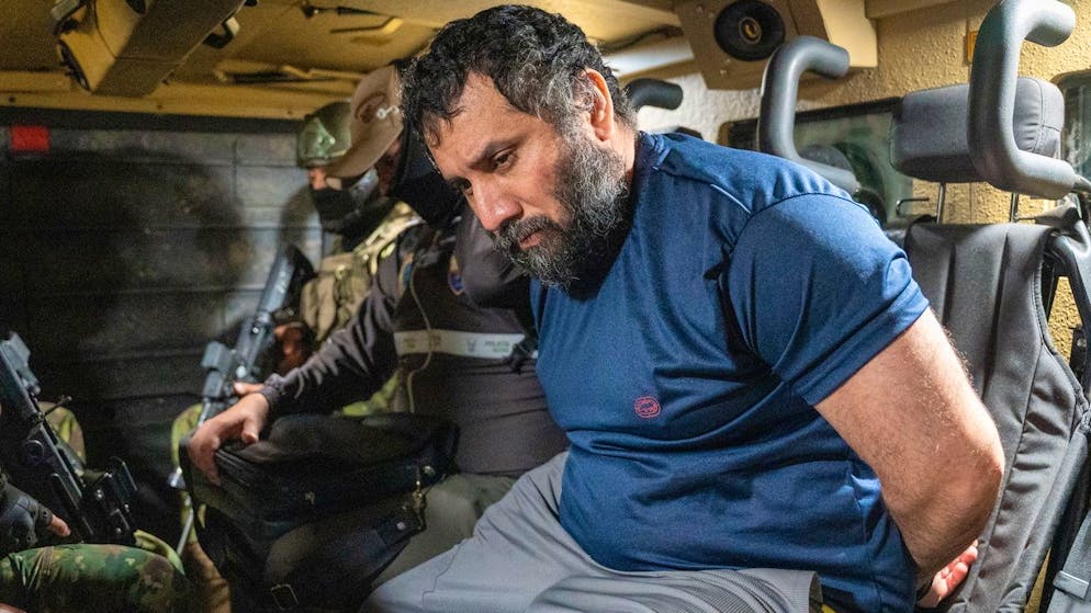 Josè Adolfo MacÌas Villamar wird nach seiner erneuten Festnahme von Soldaten und Polizisten bewacht.