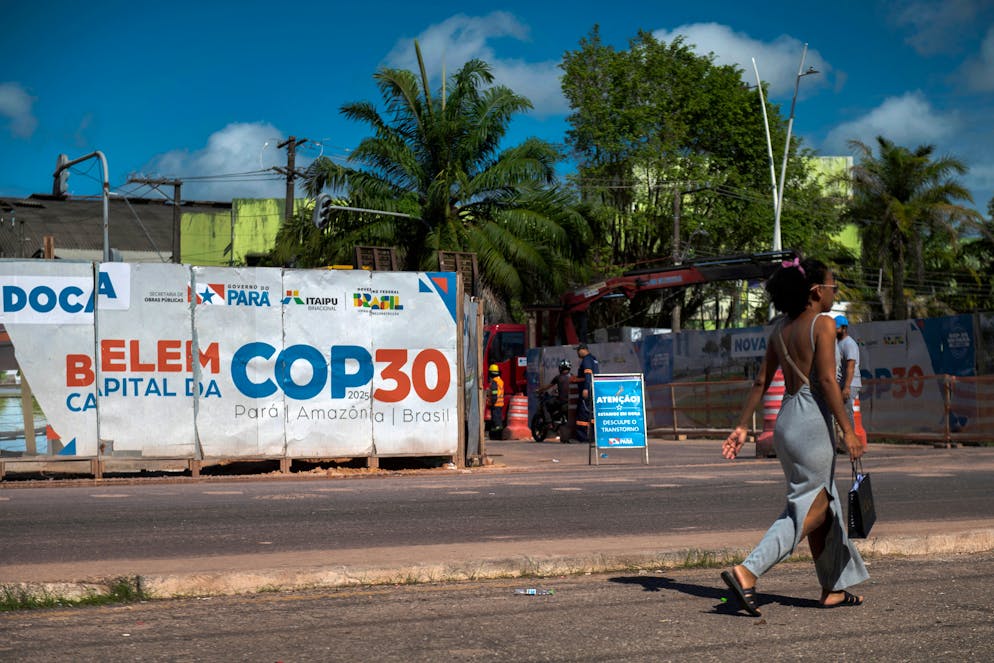 A woman passes in front of an infrastructure site underway for COP30 in Belém, in the state of Pará, in Brazil, June 16, 2025. Meanwhile, Brazil will host the United Nations Climate Conference, COP30, in November in the Amazonian city of Belém. In addition, (Photo of Carlos Fabal / AFP) "shocking discriminatory" - "vertiginous prices"