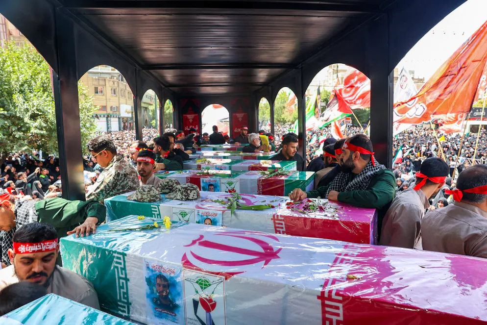 In this picture obtained from Iran's ISNA news agency, mourners stand next to the bodies of people killed in Israeli strikes during the 12-day war between Israel and Iran, during their funeral procession in the city of Mashhad on June 27, 2025. (Photo by Mohammad ALERASOOL / ISNA / AFP)