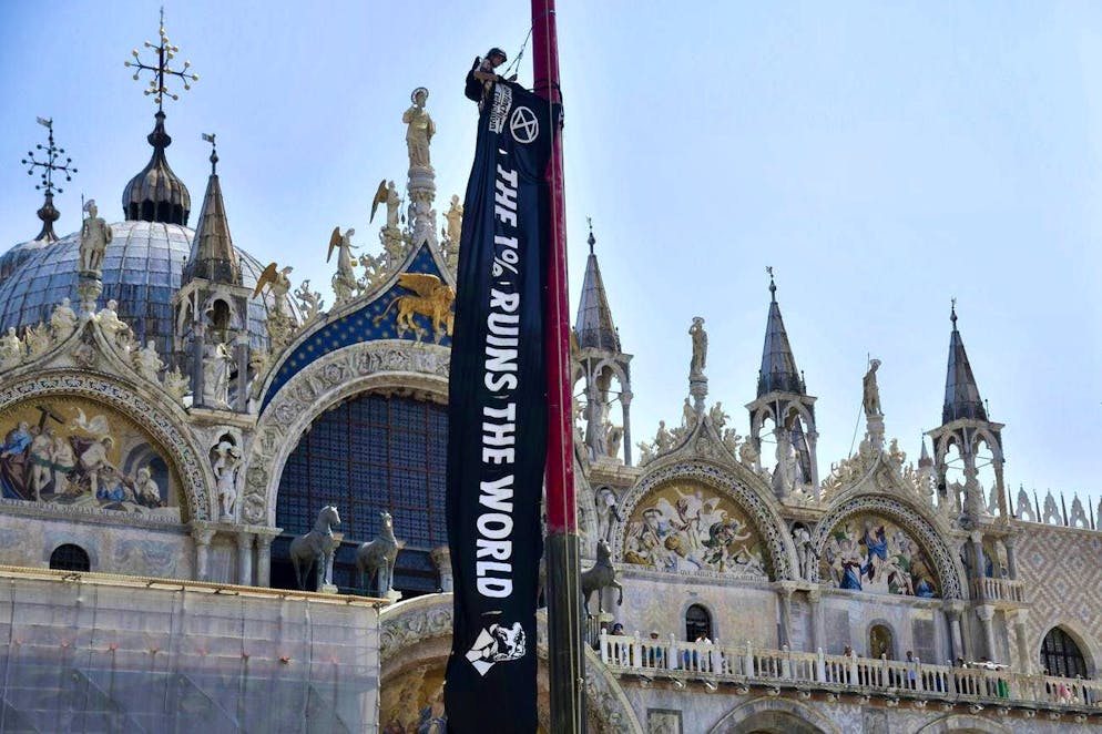 Le foto più belle del matrimonio di Jeff Bezos e Lauren Sánchez. Un attivista del movimento ambientalista Extinction Rebellion appende uno striscione davanti alla Basilica di San Marco.