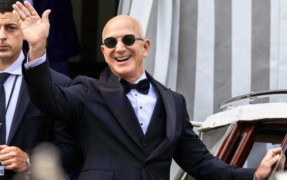 Jeff Bezos waves to the few media representatives admitted before the wedding ceremony with his future wife Lauren Sánchez.