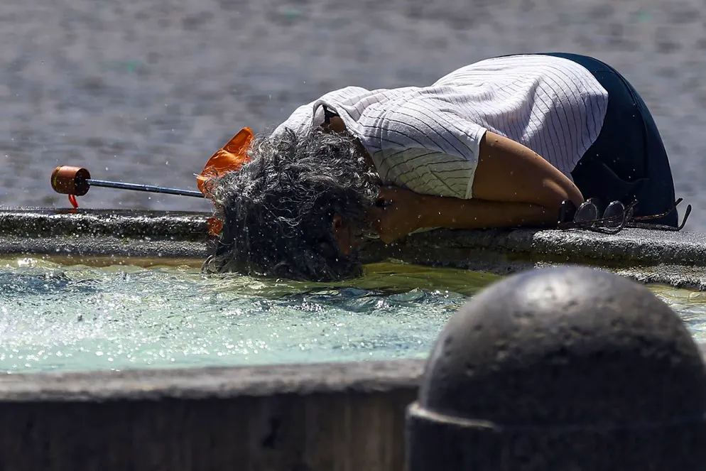 epa12202764 Des personnes se rafraîchissent dans une fontaine pendant une vague de chaleur, à Rome, en Italie, le 28 juin 2025. EPA/ANGELO CARCONI