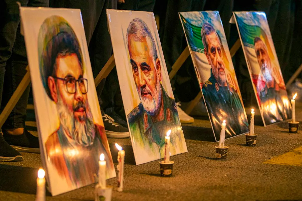 Des photos du dirigeant assassiné du Hezbollah libanais, Hashem Safieddine (à g.), du commandant des Gardiens de la révolution islamique iranienne (IRGC), Qassem Soleimani (2e à g.), et d'autres figures, sont exposées lors d'une veillée en mémoire des membres de l'IRGC et des scientifiques tués lors des récentes frappes aériennes israéliennes, devant le siège de l'ambassade d'Iran à Bagdad, le 28 juin 2025.