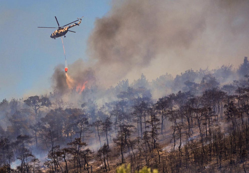 Smoke rises while firefighters intervene on a forest fire in Foca, Izmir, Türkiye, June 14, 2025.