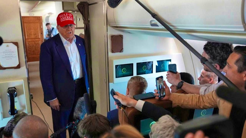 US President Donald Trump (M) speaks with reporters on Air Force One on the flight back to Joint Base Andrew after visiting a migrant detention center in Ochopee, Florida. Photo: Evan Vucci/AP/dpa