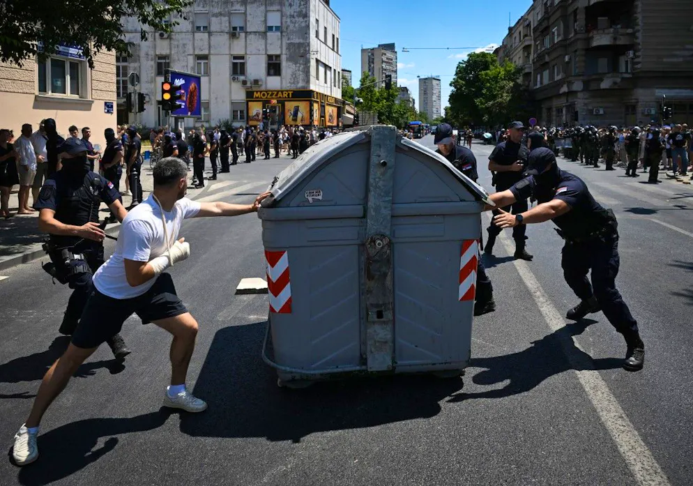 Un manifestant tente d’empêcher la police de retirer une poubelle bloquant une rue lors d’une manifestation antigouvernementale à Belgrade, le 30 juin 2025.