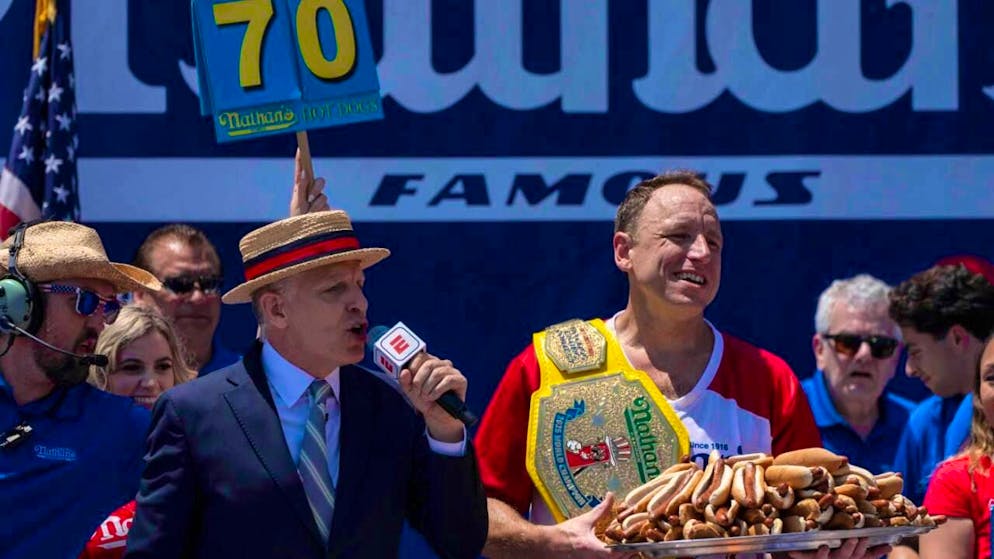 Competitive eater Joey Chestnut celebrates after winning the Nathan's Famous hot dog eating contest. Photo: Yuki Iwamura/AP/dpa