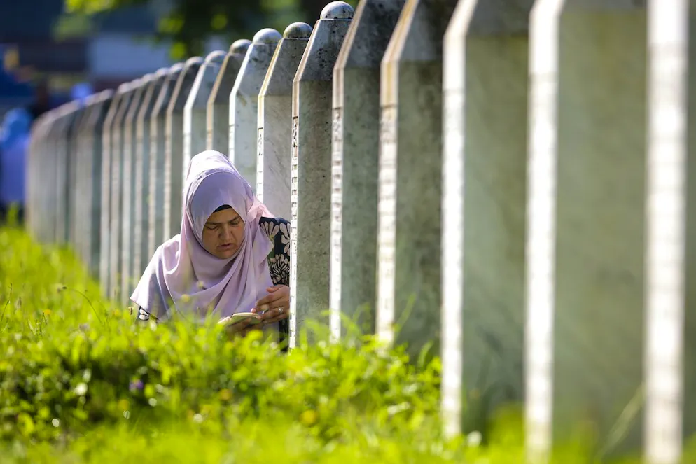 Une femme musulmane bosniaque prie près de la tombe d'un proche, victime du massacre de Srebrenica, au Centre mémorial de Srebrenica à Potocari, en Bosnie, le jeudi 11 juillet 2024. Des milliers de personnes se sont rassemblées dans la ville de Srebrenica, dans l'est de la Bosnie, pour commémorer le 29e anniversaire du massacre de Srebrenica, seul génocide reconnu en Europe depuis l'Holocauste. (AP Photo/Armin Durgut)
