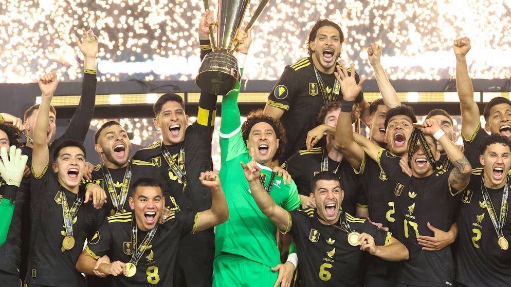 Mexikos Captain Edson Álvarez und Ersatz-Goalie Guillermo Ochoa stemmen nach dem Finalsieg gegen die USA den Siegerpokal in die Höhe.