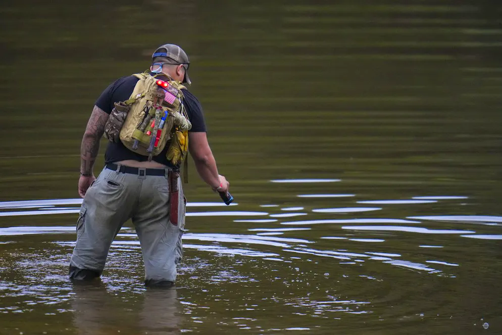 Avi Santos, 23 anni, un civile di San Antonio, Texas, guadando il fiume Guadalupe mentre aiuta nelle operazioni di soccorso vicino a Camp Mystic dopo che un'improvvisa inondazione ha colpito la zona domenica 6 luglio 2025 a Hunt, Texas.