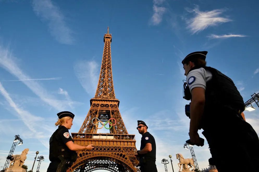Des policiers français montent la garde devant la tour Eiffel, à Paris, le 21 juillet 2024