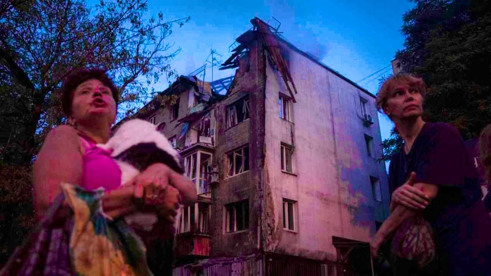 dpatopbilder - Residents stand in front of their house, which was badly damaged by a Russian attack. Photo: Evgeniy Maloletka/AP/dpa