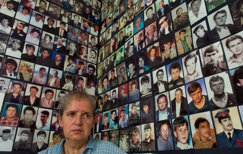 Hajra Catic, survivante du massacre de Srebrenica, se tient à côté de dizaines de photos de citoyens disparus de Srebrenica, après que l'enclave sécurisée par l'ONU soit tombée aux mains des Serbes de Bosnie en juillet 1995, à l'Association des veuves de Srebrenica à Tuzla, le mercredi 29 juin 2005.