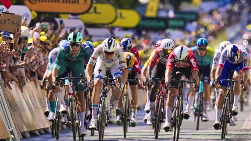 Tim Merlier (in white) wins the sprint on stage 9 of the Tour de France.
