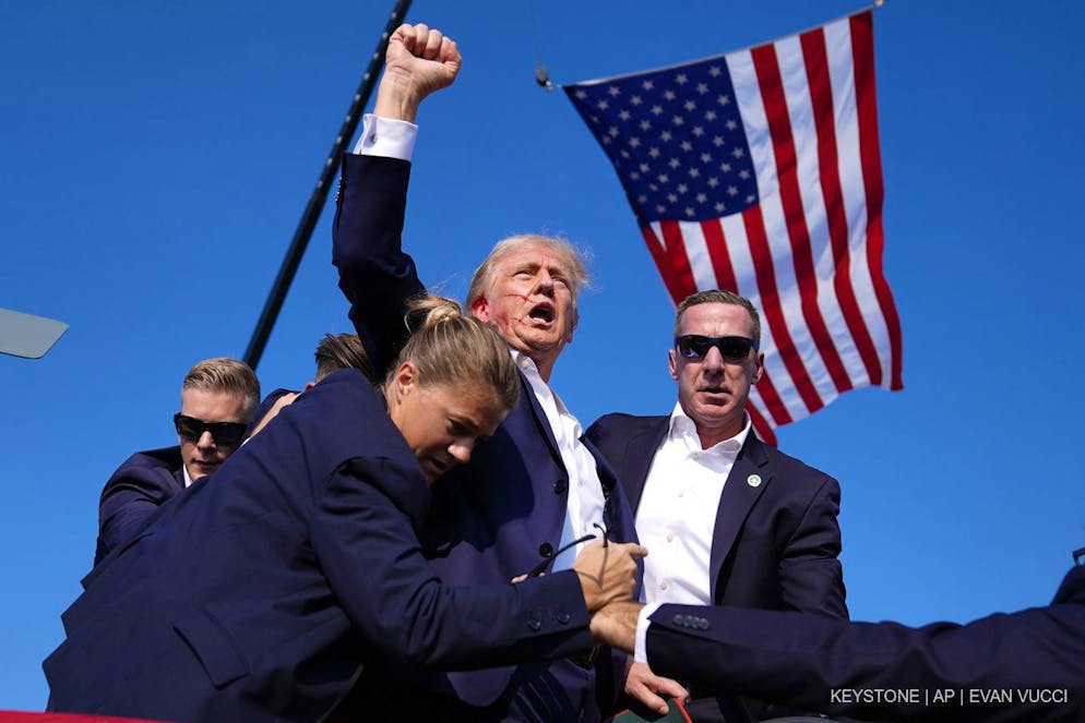 Donald Trump in Kampfpose nach dem Attentatsversuch auf ihn am Samstag, den 13. Juli 2024, bei einer Wahlkampfkundgebung in Pennsylvania, umgeben von Agenten des Secret Service.