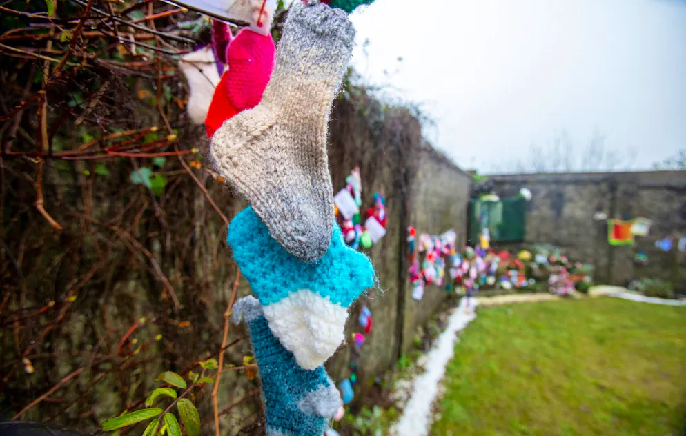 Baby socks and hearts are pictured at a shrine in Tuam, County Galway in January 13, 2021, erected in memory of up to 800 children who were allegedly buried at the site of the former home for unmarried mothers run by nuns. Irish prime minister Micheal Martin on Wednesday formally apologised for the treatment of unmarried women and their babies in state and church-run homes, where thousands of children died over decades. Some 9,000 children died in Ireland's "mother and baby homes", where unmarried mothers were routinely separated from their infant offspring, according to an official report published Tuesday. (Photo by Paul Faith / AFP)