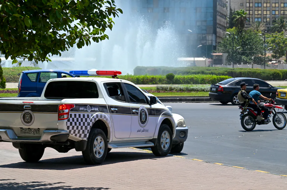 Un homme armé circule à moto sur la place Ummayad de Damas, près du quartier général de l'armée syrienne, après qu'Israël a déclaré avoir frappé le site militaire situé à proximité, le 16 juillet 2025.