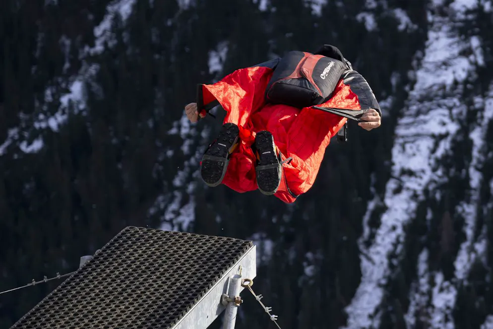 Un base jumper équipé d'une combinaison ailée sautant d'une plateforme vers la vallée, en contrebas de Muerren, dans la région de Lauterbrunnen.