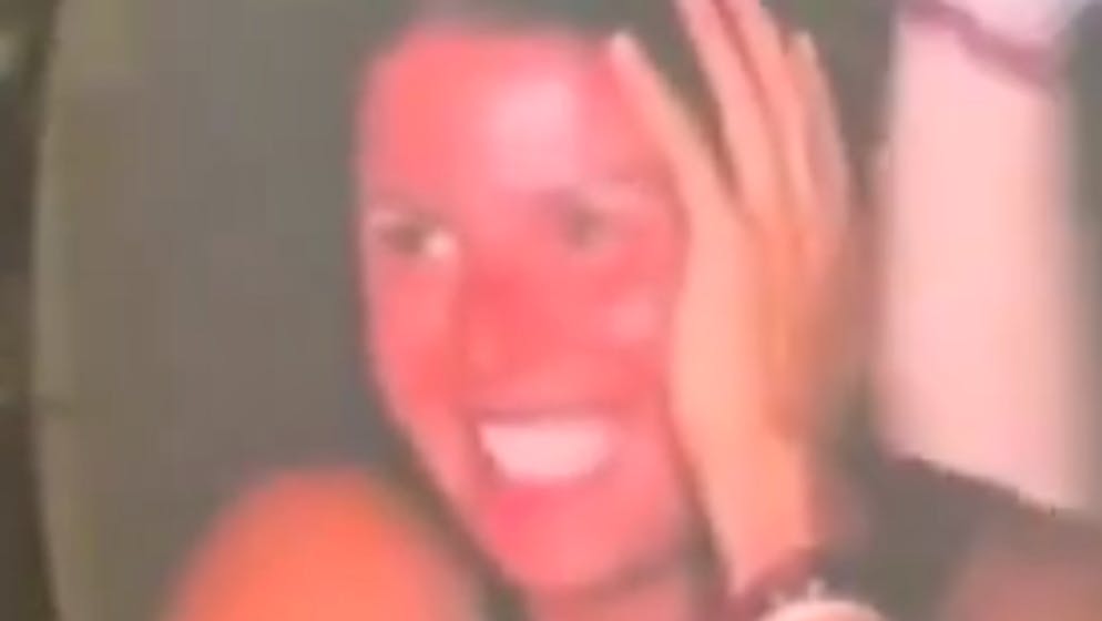 She laughs awkwardly. Who is the mysterious woman next to the affair couple?