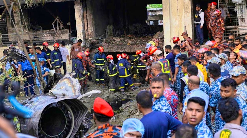 Firefighters search for the survivors of a Bangladesh Air Force training plane that crashed into a school campus shortly after take-off. Photo: Mahmud Hossain Opu/AP/dpa