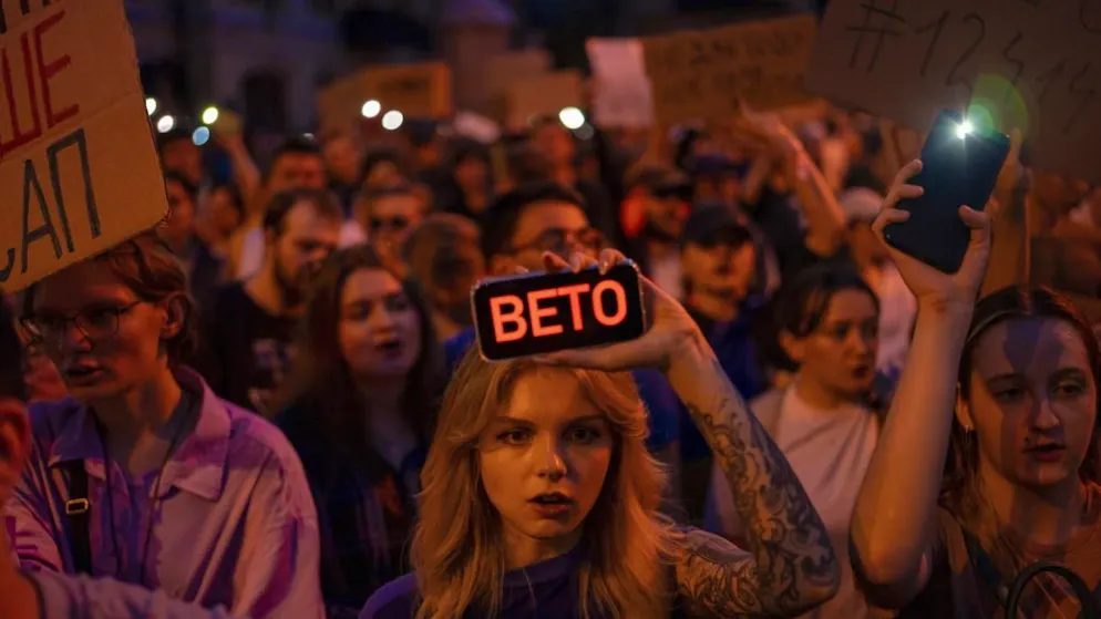 Una donna mostra il telefonino con la scritta «Veto» durante le proteste contro la nuova legge sugli organi anticorruzione a Kiev.