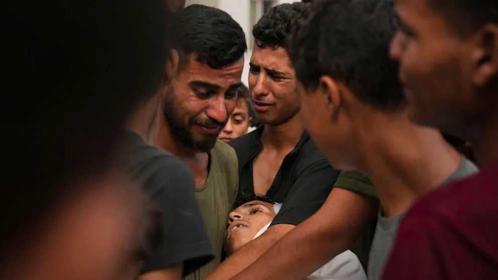 Gaza: 2 nouveaux morts dans des attaques israéliennes - Gallery. Des Palestiniens à l'hôpital Al-Chifa, près du corps d'un proche tué alors qu'il tentait d'approcher les camions d'aide.