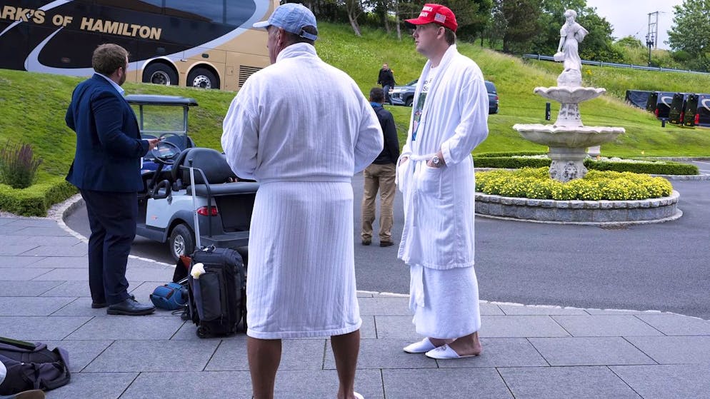 Trump-Anhänger in Morgenmänteln und Hotel-Slippern warten am Sonntag auf Trump Turnberry in Schottland, während der US-Präsident mit  EU-Kommissionspräsidentin Ursula von der Leyen auf Trumps Golfplatz verhandelt.