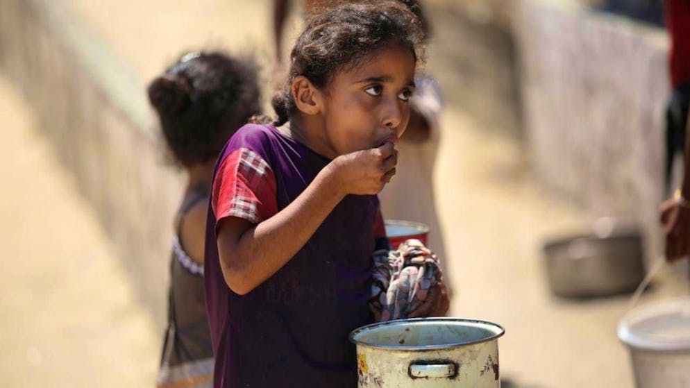Internally displaced Palestinians arrive at a charity kitchen in the Palestinian refugee camp of Nuseirat in the center of the Gaza Strip to receive limited food rations. Photo: Ahmed Ibrahim/APA Images via ZUMA Press Wire/dpa