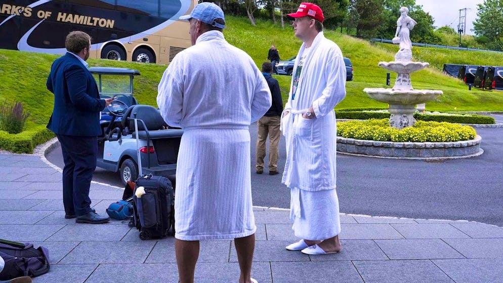 Trump supporters in robes and hotel slippers wait for Trump Turnberry in Scotland on Sunday while the US President negotiates with EU Commission President Ursula von der Leyen on Trump's golf course.