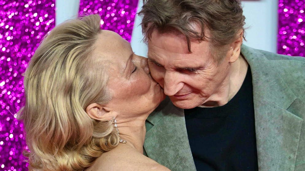 Pamela Anderson kisses Liam Neeson on the cheek at the premiere of "The Naked Gun" in London on July 22, 2025.
