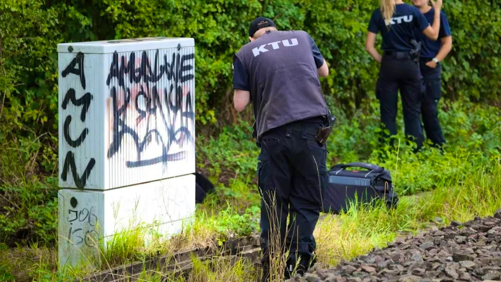 An employee of the KTU (forensic investigation unit) stands by a "concrete tub" at the edge of the railroad tracks containing burnt cables. Another arson attack has been carried out on the important north-south line of Deutsche Bahn. Photo: Christoph Reichwein/dpa
