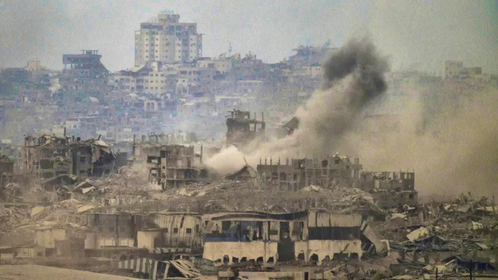 Smoke rises amid destroyed buildings after Israeli shelling in the Gaza Strip, seen from southern Israel. Photo: Leo Correa/AP/dpa