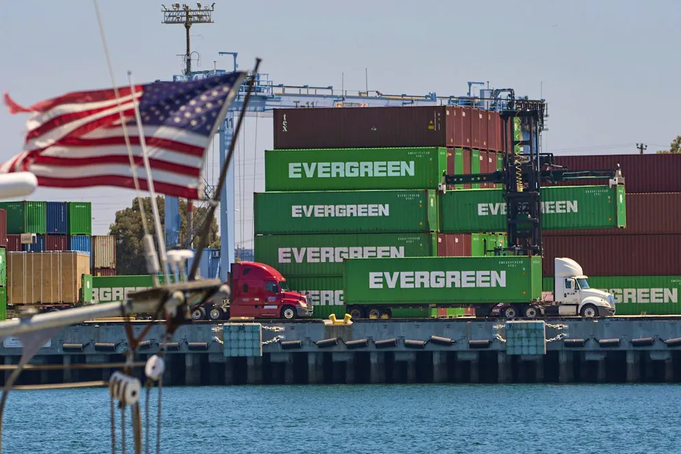 Shipping containers sit stacked at the Evergreen terminal at the port of Los Angeles, Friday, Aug. 1, 2025. (AP Photo/Damian Dovarganes)
