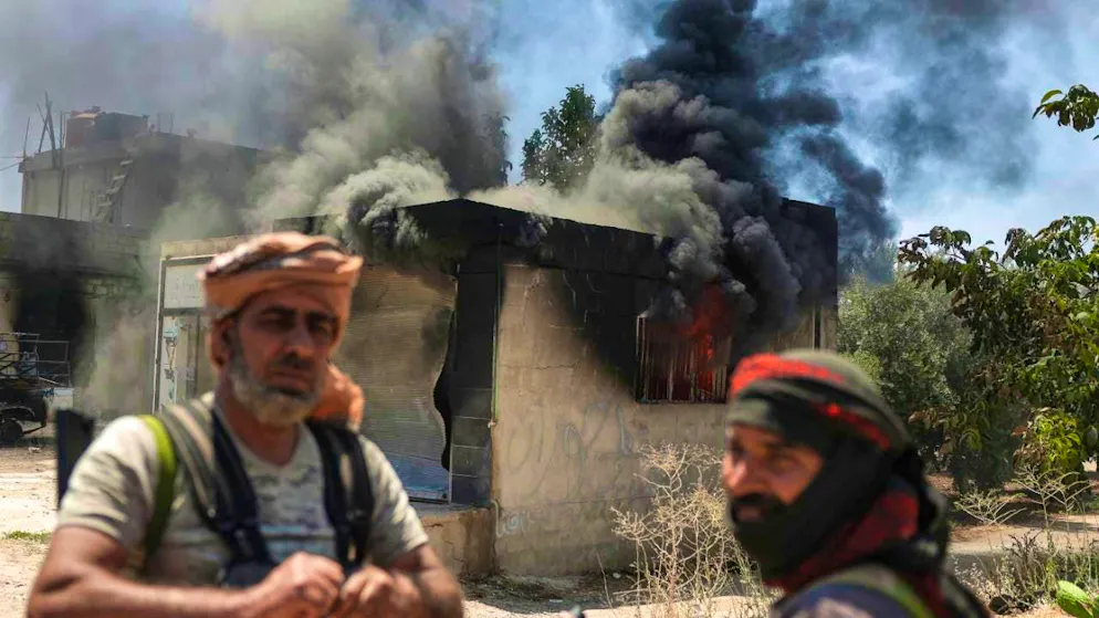 ARCHIVE - Bedouin fighters stand in front of a burnt down store in the village of Al-Masraa on the outskirts of the town of Suwaida during clashes between Bedouin tribal fighters and Druze forces. Photo: Ghaith Alsayed/AP/dpa/archived image