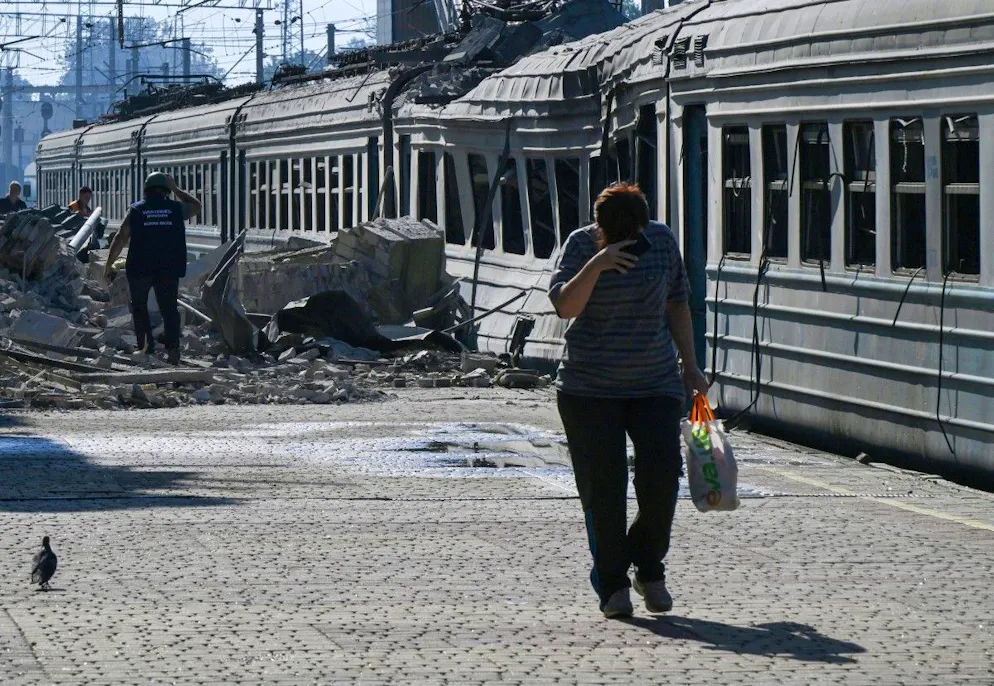 Un habitant passe devant un train de voyageurs endommagé sur le site d'une frappe de drone dans la ville de Lozova, dans la région de Kharkiv, le 5 août 2025, alors que la Russie envahit l'Ukraine (archives).